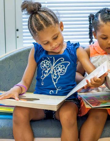 HERO girls reading on couch